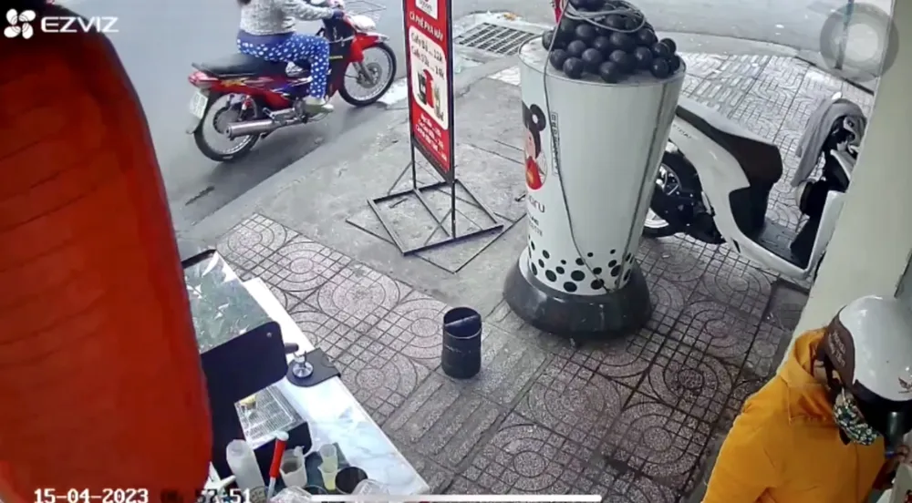 Người phụ nữ áo vàng đi vào trong trộm điện thoại, người còn lại đợi ngoài xe máy. Ảnh cắt từ clip