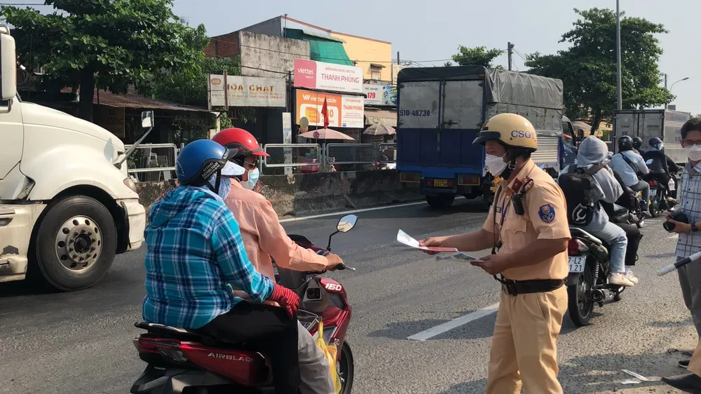 CSGT tặng tờ rơi tuyên truyền luật giao thông cho người dân về quê