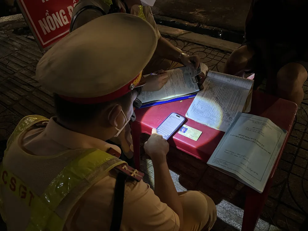 CSGT kiểm tra bằng lái xe của tài xế M. và phát hiện đây là bằng lái giả. Ảnh: NGUYỄN YÊN