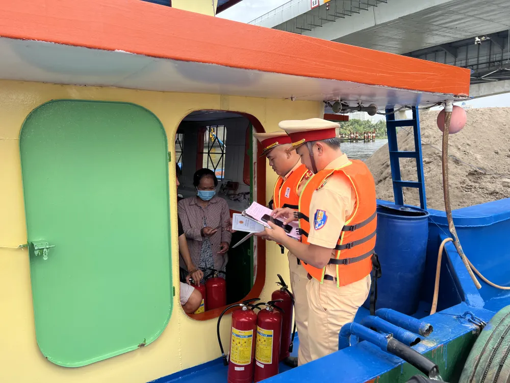 Kiểm tra giấy tờ, chứng chỉ, dụng cụ trên một sà lan. Ảnh: NGUYỄN YÊN