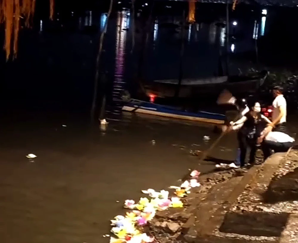 Nhóm người đứng trên bờ lấy đá ném về phía các thanh niên đang ở dưới sông. Ảnh cắt từ clip