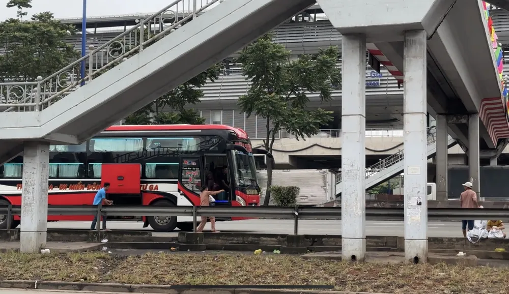 Xe khách đón khách dưới chân cầu đi bộ Suối Tiên sáng 31-8.