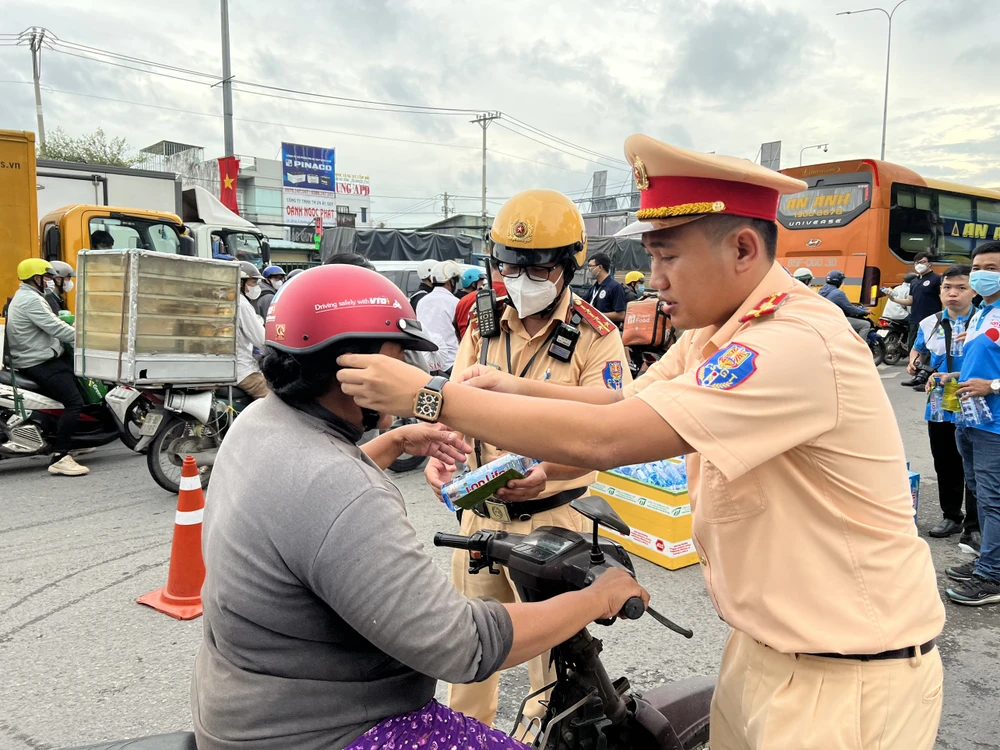 CSGT đổi nón bảo hiểm cho một người dân chiều 31-8.