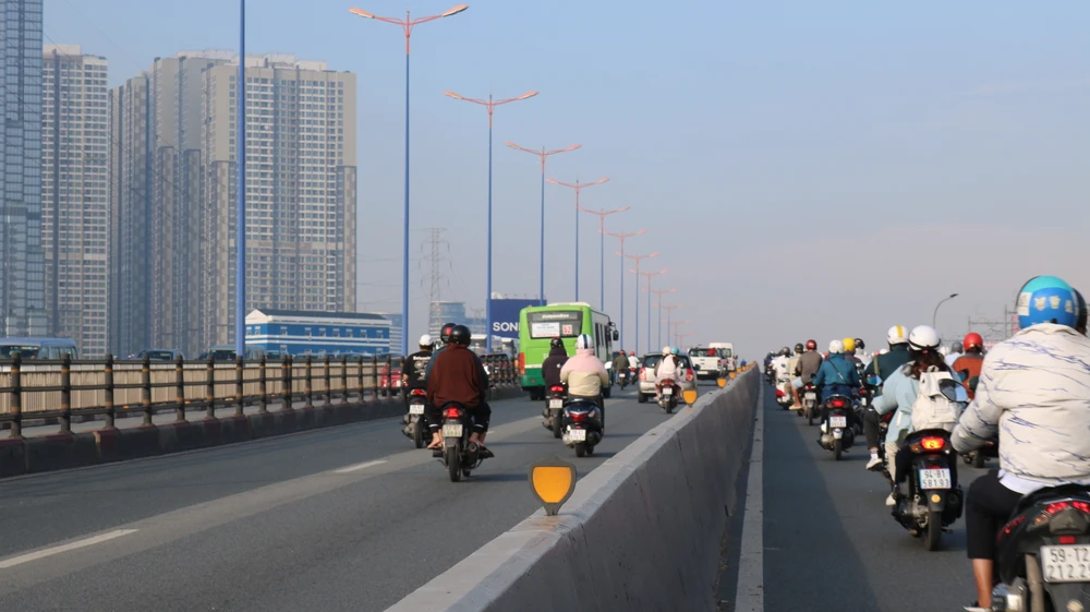 Nhiều xe máy di chuyển bất chấp biển cấm và nguy hiểm, phóng nhanh trên làn đường dành cho ô tô. Ảnh: HỒNG THẮM Không chỉ chạy vào làn ô tô, nhiều xe mô tô chạy dàn hàng, vượt mặt ô tô, xe buýt..JPG