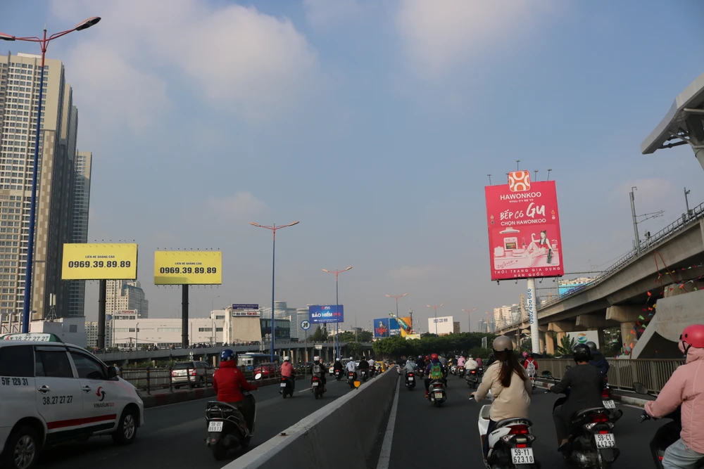 Hàng chục xe máy di chuyển vào làn ô tô trong một khung hình được chụp vào sáng 8-11. Ảnh: HỒNG THẮM Lượng xe máy giữa làn dành cho ô tô và làn dành cho xe máy có lúc ngang nhau.JPG
