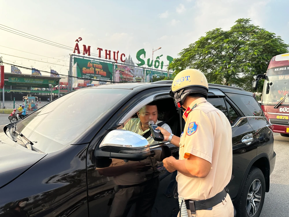 CSGT kiểm tra nồng độ cồn với một lái xe tại chốt trước KDL Suối Tiên. Ảnh: NGUYỄN YÊN csgt-tp-hcm-bat-dau-cao-diem-kiem-soat-quoc-lo-1-6.jpg