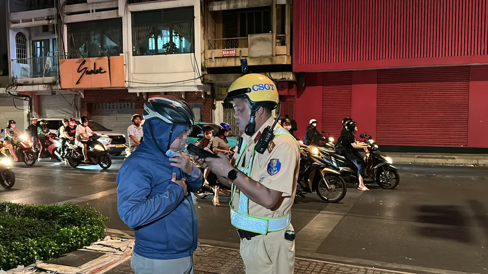 CSGT kiểm tra nồng độ cồn của ông Th. Ảnh: NGUYỄN YÊN vi-pham-nong-do-con-kich-khung-vua-quay-phim-csgt-vua-noi-toi-rat-hoi-han (2).jpg