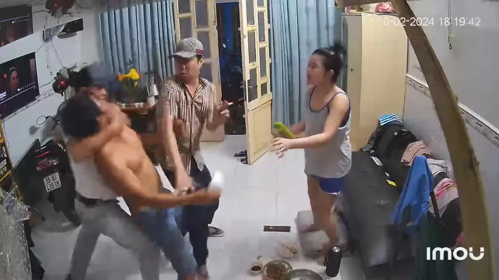 Người đàn ông áo trắng kẹp cổ anh B lại cho ông Sang hành hung. Ảnh: Cắt từ clip Mùng 1 Tết, nhóm chủ nợ lao vào nhà, hành hung hội đồng con nợ (5).jpg