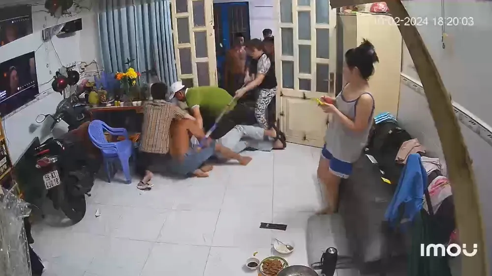 Người phụ nữ dùng cây lau nhà đánh anh B khi anh này bị cùng lúc nhiều người đàn ông khác đánh hội đồng. Ảnh: Cắt từ clip Mùng 1 Tết, nhóm chủ nợ lao vào nhà, hành hung hội đồng con nợ (7).jpg