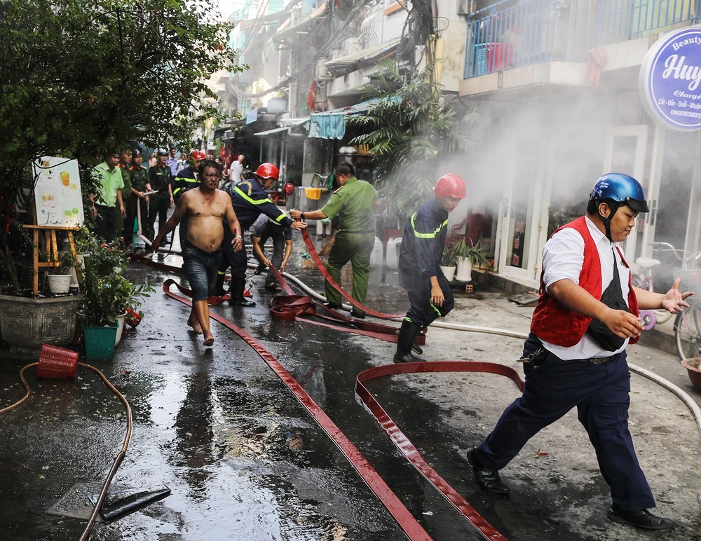 Nỗ lực dập tắt đám cháy trong hẻm số 5 Nguyễn Trung Ngạn. Ảnh: ĐC Cháy lớn căn nhà dưới chân cầu Ba Son, quận 1