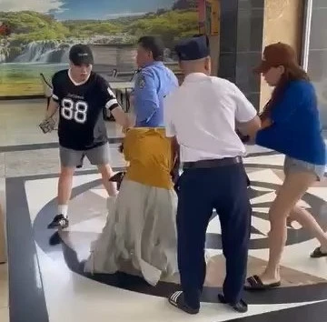 Hình ảnh Quý (áo xanh) và Tú (áo đen) cùng hành hung chị M ở sảnh chung cư La Bonita. Ảnh cắt từ clip Khởi tố hoa khôi UEF xưng luật sư, đánh ghen giúp bạn
