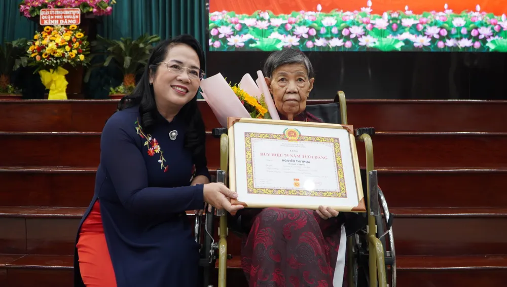 Bà Trần Kim Yến, Chủ tịch Ủy ban MTTQ Việt Nam TP.HCM trao huy hiệu 75 năm tuổi Đảng cho bà Nguyễn Thị Thoa. Quận Phú Nhuận trao huy hiệu Đảng cho 119 Đảng viên cao tuổi