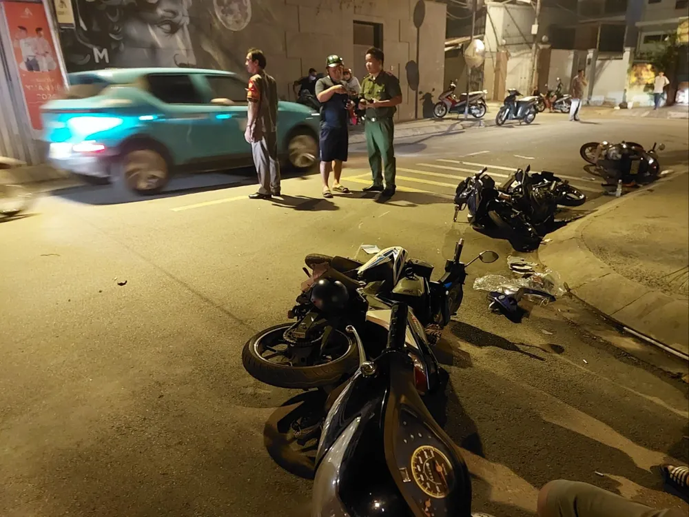 Xe máy bị tông nằm la liệt trên mặt đường. nu-tai-xe-taxi-dien-lai-xe-tong-hang-loat-xe-may-o-quan-10-post0.html5.jpg