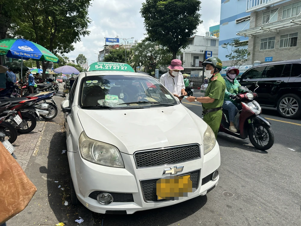 Công an quận 3 kiểm tra một xe taxi hãng 27/7 trên đường Lý Chính Thắng sáng 5-6. Qua kiểm tra, xe này có đầy đủ giấy tờ, pháp lý hợp lệ kinh doanh taxi. Xe này chỉ vi phạm về dừng đỗ sai quy định. Ảnh: TÂN YÊN lanh-dao-hop-tac-xa-27-7-dong-300-ngan-lo-cho-anh-chay-ma-khong-bi-bat (1).jpg