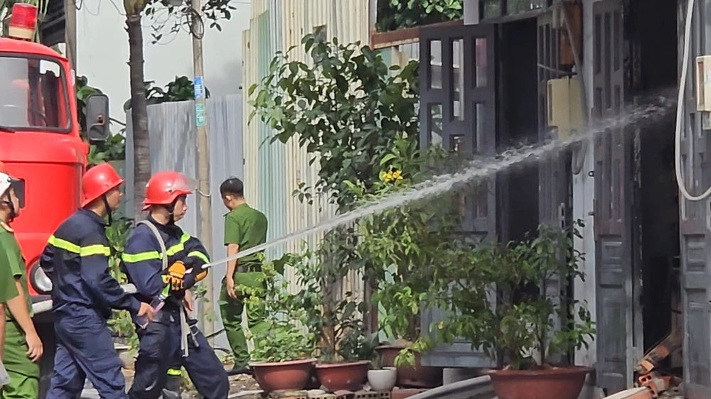 Cảnh sát đang dập lửa tại khu vực kho vải đang cháy. Ảnh: HT chay-kho-vai-o-binh-tan-nhieu-nguoi-thao-chay (1).jpg