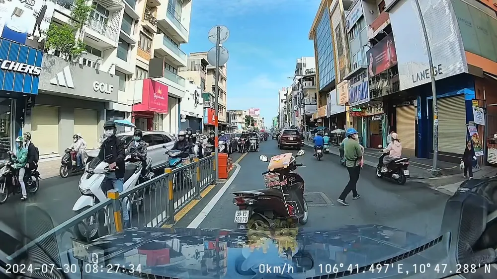 Hình ảnh ông T bỏ lại xe máy giữa đường gây cản trở giao thông được camera hành trình xe ô tô ghi lại. Ảnh cắt từ clip Xử phạt người đàn ông chở trẻ em đi ngược chiều, bỏ xe giữa đường cản trở giao thông