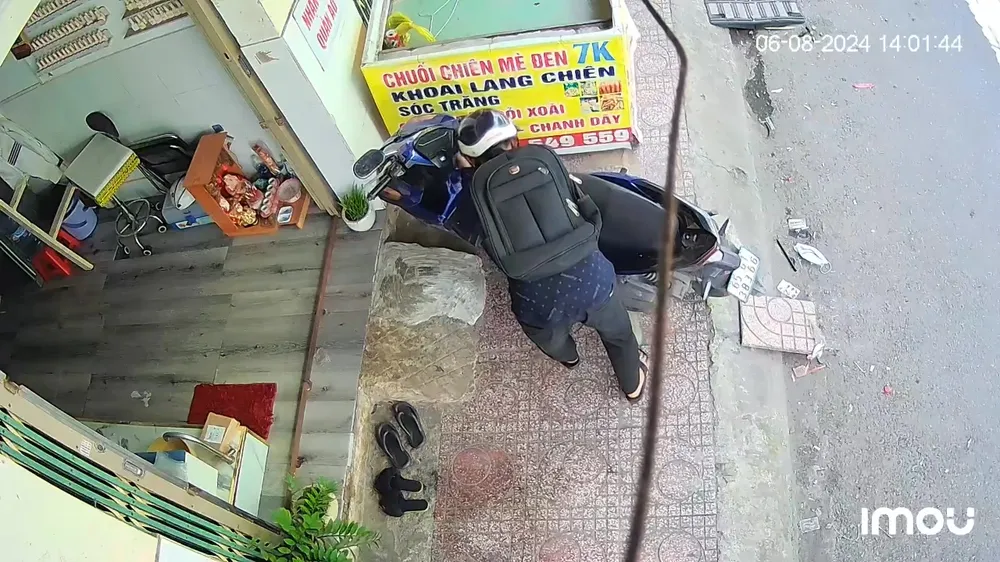 Nam thanh niên tiếp cận xe máy của nạn nhân đang dựng trước cửa hàng. Ảnh cắt từ clip Hy hữu trộm vào tận nhà nạn nhân lấy chìa khóa rồi trộm xe máy