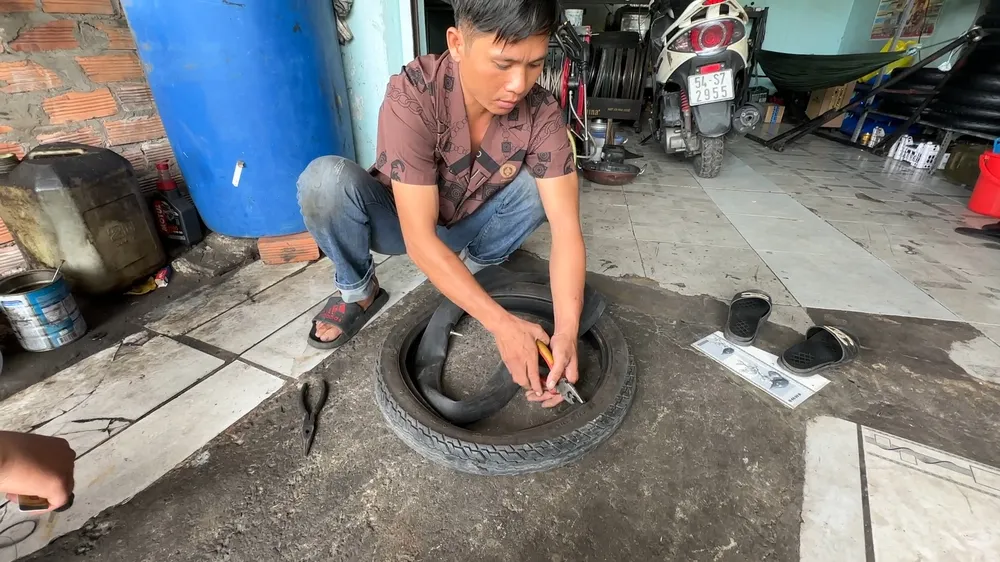 Cường "biểu diễn" lại hành vi dùng kèm phá lốp và ruột xe của khách. vu-pha-xe-tren-quoc-lo-cong-an-tp-thu-duc-tim-bi-hai-cua-tiem-duoi-chan-cau-vuot-go-dua-1 (1).jpg