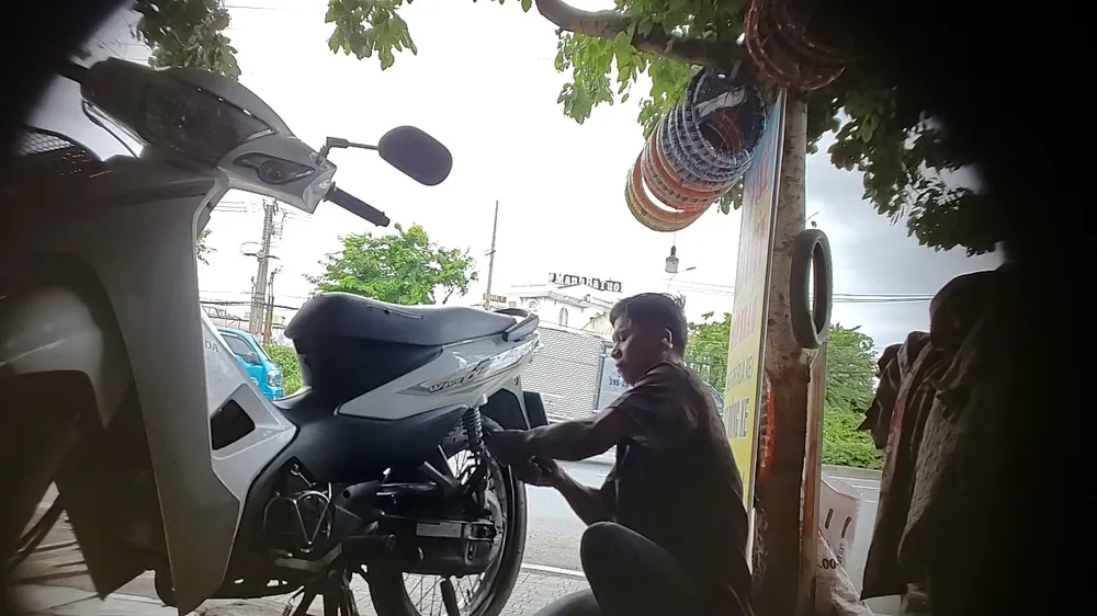 Hình ảnh Mai Văn Cường dùng kềm bẻ tanh lốp xe của PV vào ngày 18-7. Vụ phá xe trên Quốc lộ: Công an TP Thủ Đức tìm bị hại của tiệm dưới chân cầu vượt Gò Dưa