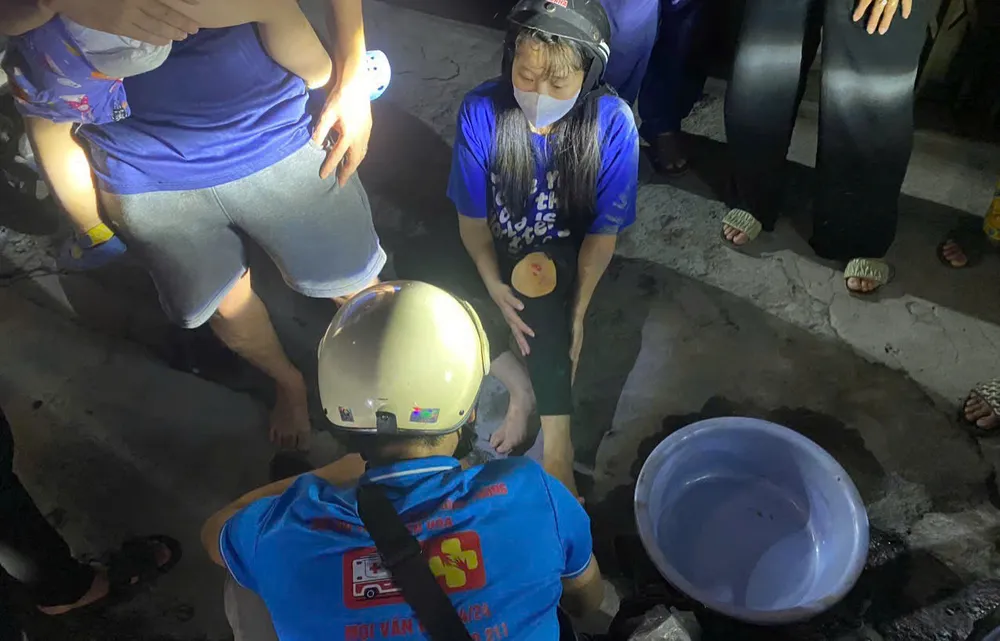Một phụ nữ bị ngã xe do đi vào vùng nhớt đổ và bị trầy xước. Ảnh: PHẠM HẢI hang-loat-nguoi-di-duong-te-nga-vi-vet-nhot-keo-dai-tren-quoc-lo-1.jpg