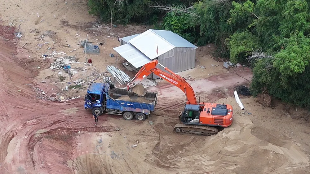 Xe múc công trình chuyển cát lên xe ben 47C-36040 vào sáng 25-7.