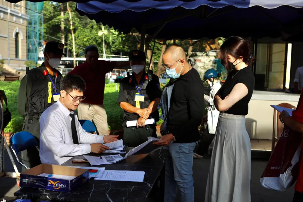 Xuất trình giấy tờ trước khi vào tòa. Ảnh: NGUYỆT NHI