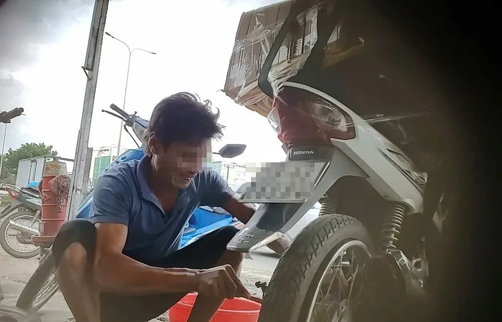 Ông Hòa dùng dụng cụ chọc đến hỏng cao su đùm để thay giá cao. Ảnh: Nhóm PV Nạn phá xe