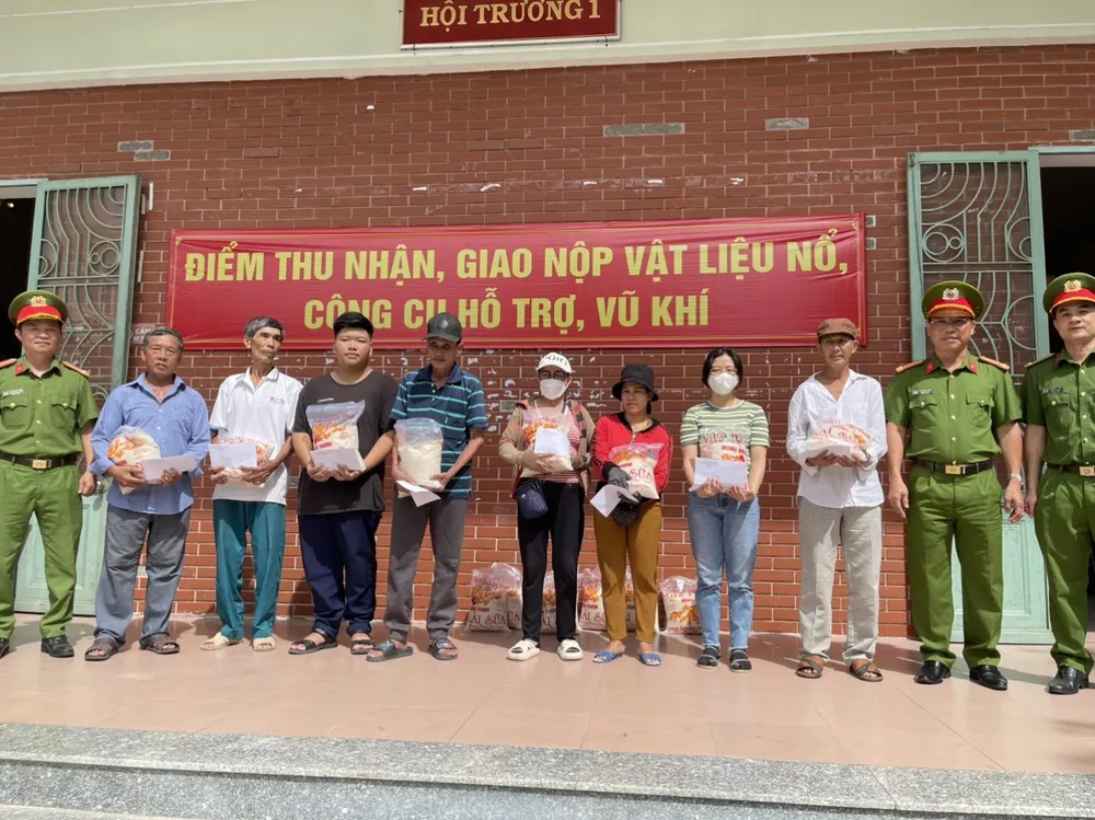 Người dân được hỗ trợ một phần quà tại điểm tiếp nhận vũ khí, vật liệu nổ. Ảnh: CA. diem thu nhan vu khi.jpg