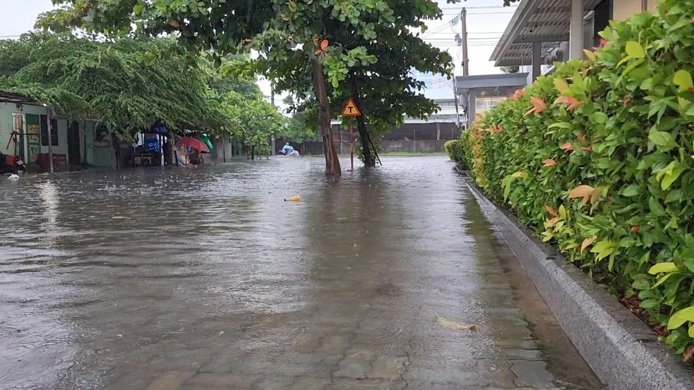Nước tràn lên hết vỉa hè, "đe doạ" nhà dân. Ảnh: MINH TRƯỜNG. da nang ngap lut kia.jpg