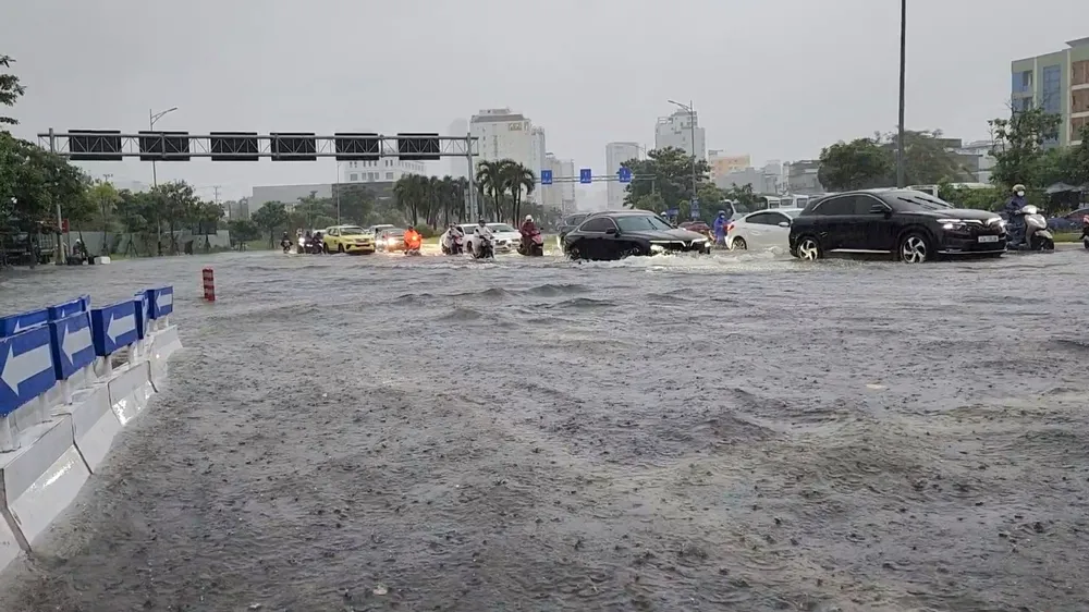 Ngã tư Phạm Văn Đồng - Ngô Quyền biến thành biển nước gây khó khăn cho người tham gia giao thông. Ảnh: MINH TRƯỜNG. da nang ngap lut pham van dong.jpg