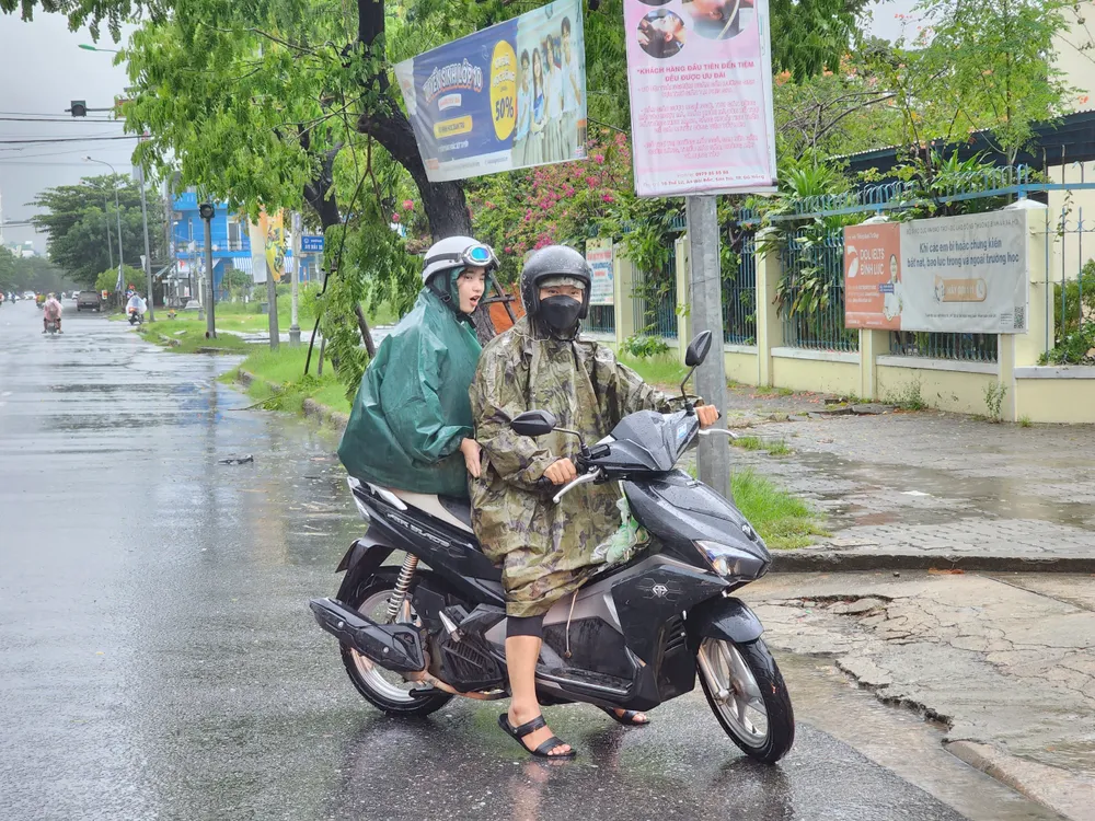 Phụ huynh học sinh ở Đà Nẵng đến trường đón học sinh về nhà. Ảnh: MINH TRƯỜNG. da nang mua lon hoc sinh.jpg