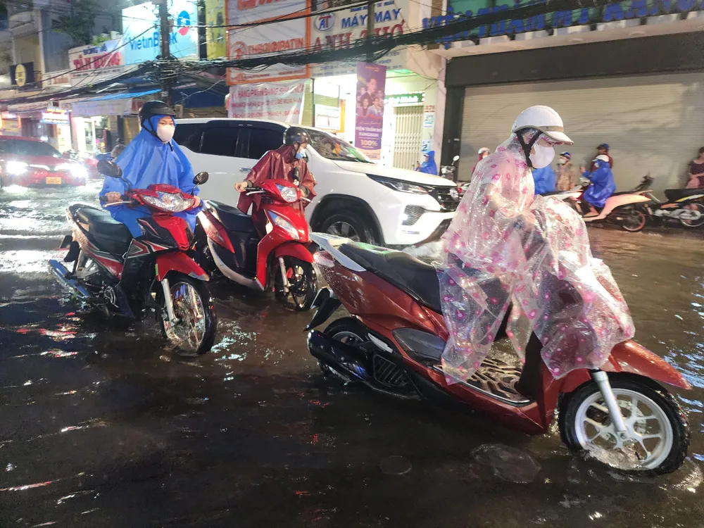 Nhiều xe máy phải đẩy bộ trên con đường ngập nước. Ảnh: MINH TRƯỜNG. hang chuc xe may day bo qua vung nuoc hung vuong.jpg