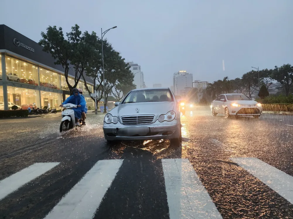 Chiếc xe hiệu Mercedes - Benz nằm giữa đường ngập nước mà không có tài xế. Ảnh: MINH TRƯỜNG. oto nam giua duong nuoc ngap.jpg
