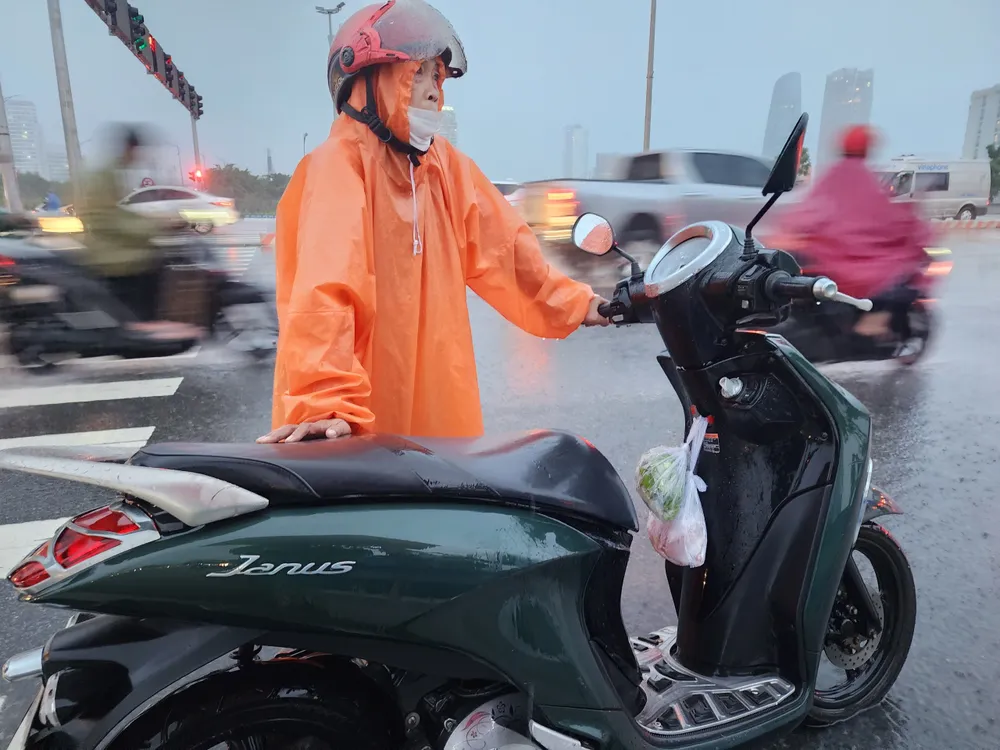 Ánh mắt lo lắng của một người mẹ khi xe bị chết máy với túi thức ăn vừa mua. Ảnh: MINH TRƯỜNG. xe may ve nha cung do an da nang.jpg