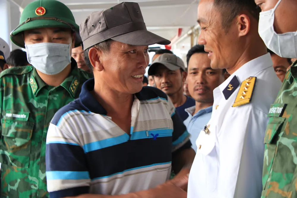 Ngư dân bắt tay, ôm thắm thiết cán bộ chiến sĩ khi rời tàu về với gia đình, bạn bè trong thể trạng sức khoẻ tốt. Ảnh: MINH TRƯỜNG. cam on.JPG