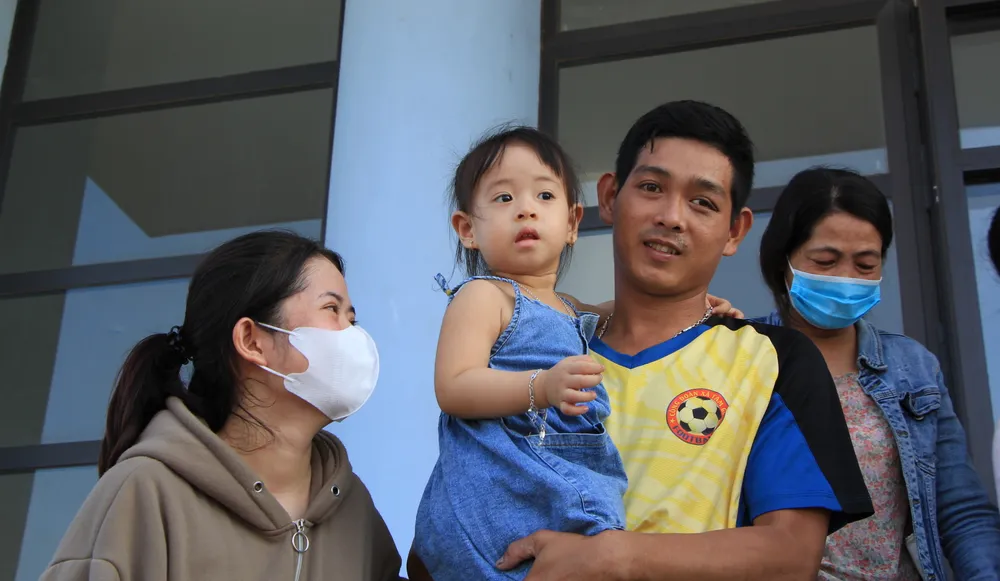 Chị Yến Nhi vui mừng khôn xiết khi được tận mắt thấy người chồng bằng xương, bằng thịt trở về ôm con gái vào lòng. Ảnh: MINH TRƯỜNG. nguoi vo cuoi cung dua con gai.JPG