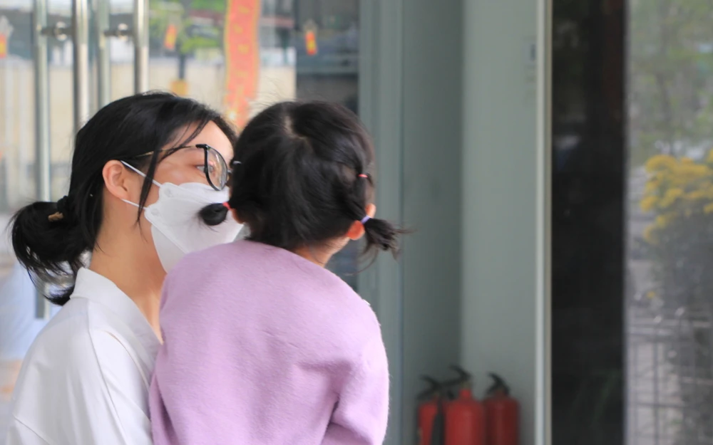 Một phụ huynh bế con đến cơ sở hỏi chuyện sau khi đọc thông tin cơ sở này bị phản ánh. Ảnh: MINH TRƯỜNG. bao-hanh-da-nang-khoc.JPG