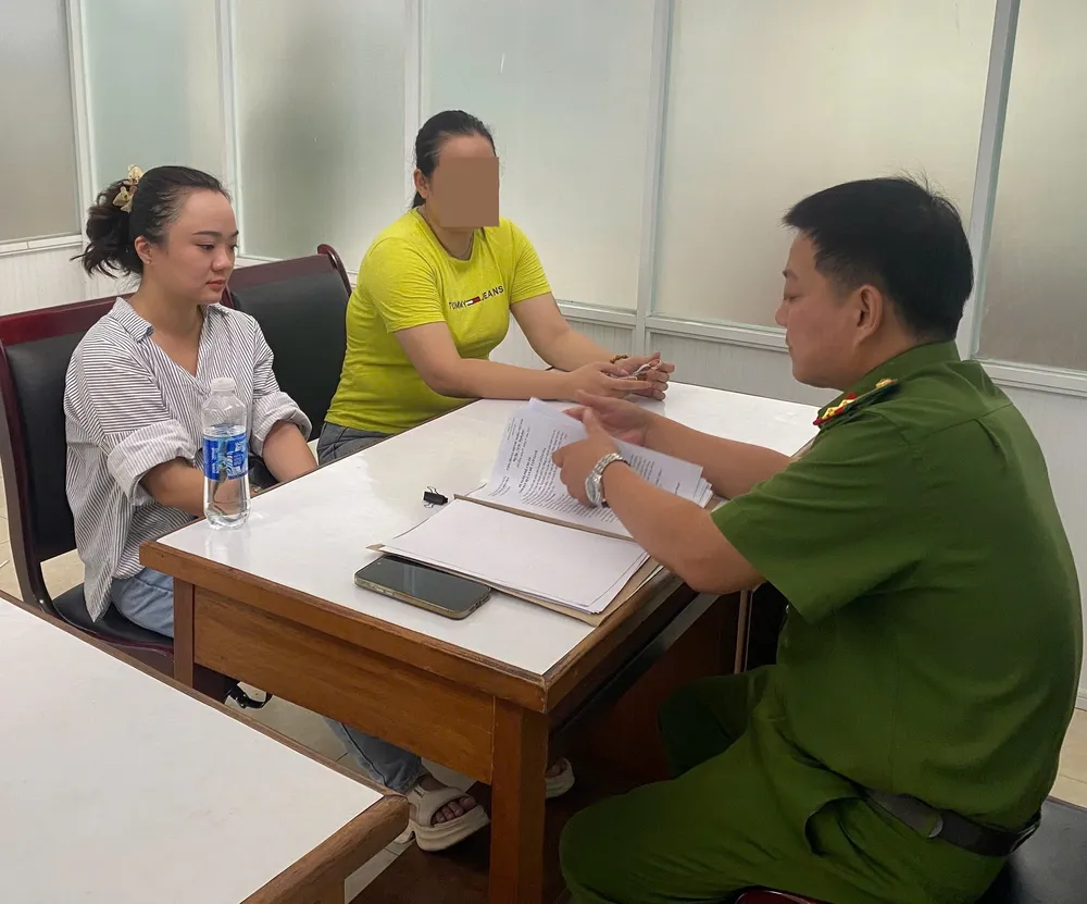 Hoài Thanh (áo trắng) làm việc với cơ quan công an. Ảnh: CA. nhân viên ngân hàng