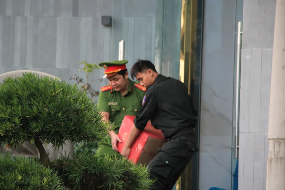Công an đưa hàng chục thùng tài liệu lên xe. Ảnh: MINH TRƯỜNG tai-lieu.JPG