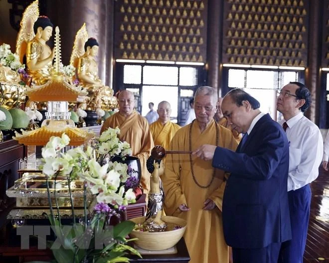 Chủ tịch nước Nguyễn Xuân Phúc thực hiện nghi thức tắm Phật khi tới thăm chùa Nghiêm. Ảnh: TTXVN