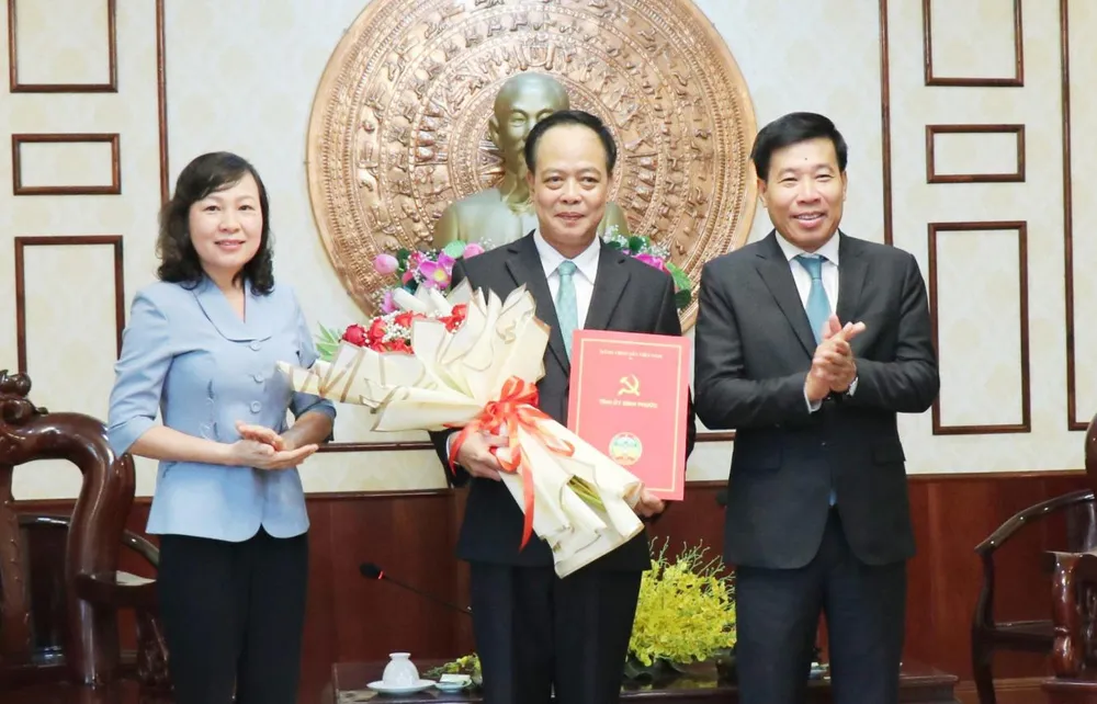 Bí thư Tỉnh uỷ Bình Phước Nguyễn Mạnh Cường, Phó Bí thư Thường trực Tỉnh uỷ Huỳnh Thị Hằng trao quyết định và tặng hoa chúc mừng ông Vũ Tiến Điền. Ảnh: Cổng TTĐT Bình Phước