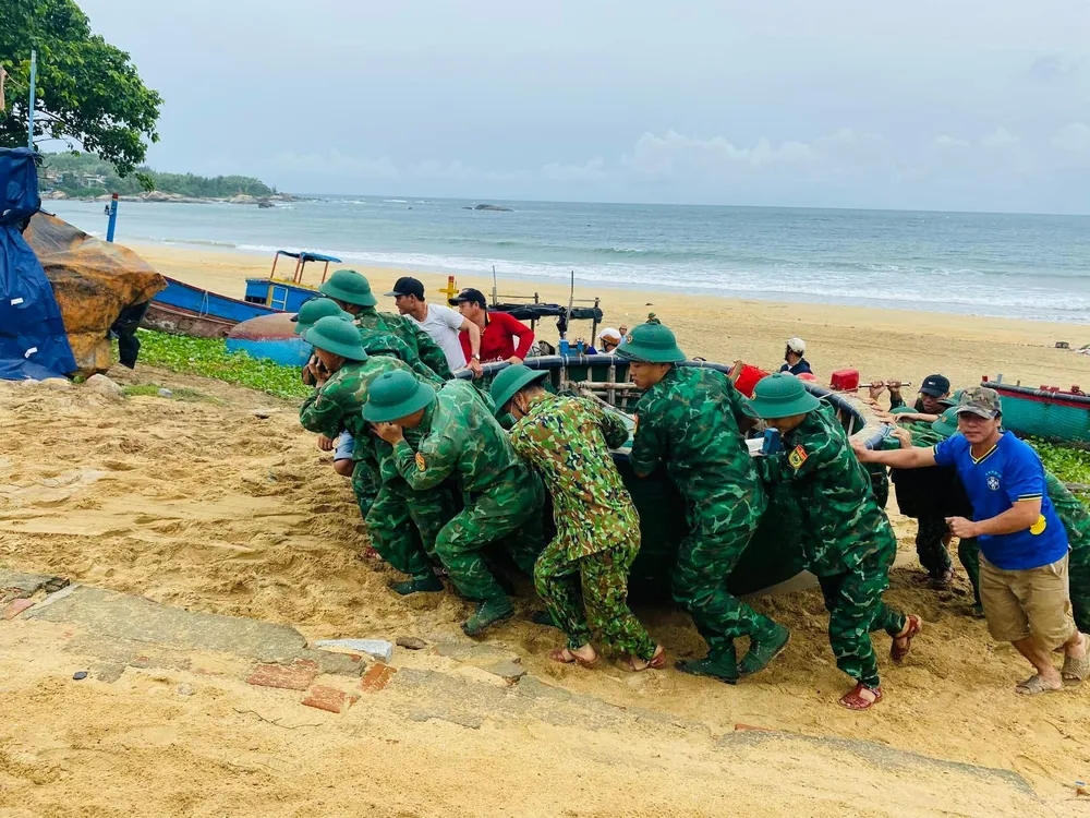 Các lực lượng, chính quyền địa phương hỗ trợ người dân đưa các phương tiện trở lại biển. Ảnh: LK
