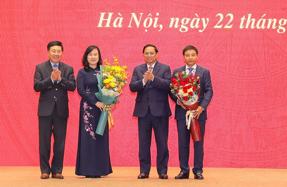 Thủ tướng Phạm Minh Chính và Phó Thủ tướng Thường trực Phạm Bình Minh tặng hoa chúc mừng hai tân Bộ trưởng. Ảnh: VGP