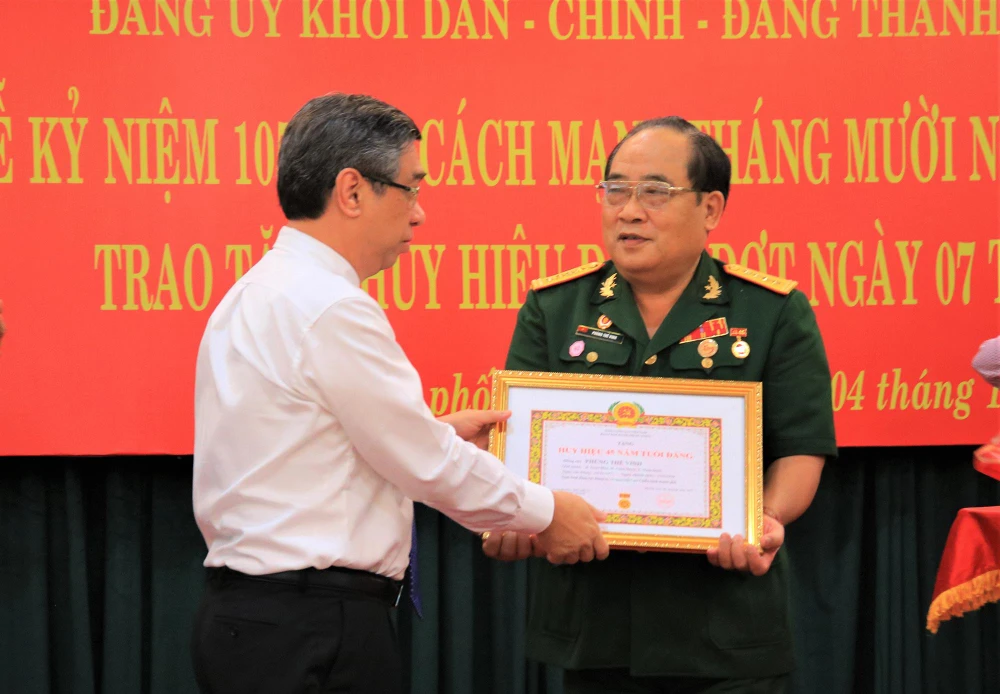 Ông Nguyễn Phước Lộc, Ủy viên Ban Thường vụ, Trưởng Ban tổ chức Thành ủy TP.HCM trao tặng Huy hiệu 45 năm tuổi Đảng cho ông Phùng Thế Vinh. Ảnh: VÕ THƠ