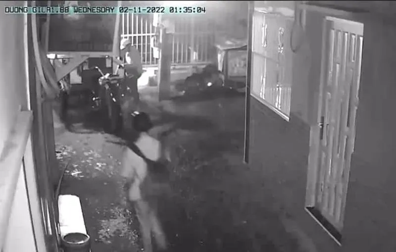 Một người đứng cảnh giới bên ngoài để người còn lại vào bẻ khóa, trộm đi chiếc ba gác. Ảnh: Cắt từ clip