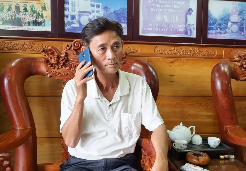 "Vua tàu cá" Sáu Ninh đang trao đổi qua điện thoại với các ngư dân đánh bắt ngoài khơi. Ảnh: TẤN LỘC "Vua tàu cá" Sáu Ninh đang trao đổi qua điện thoại với các ngư dân đánh bắt ngoài khơi. Ảnh: TẤN LỘC