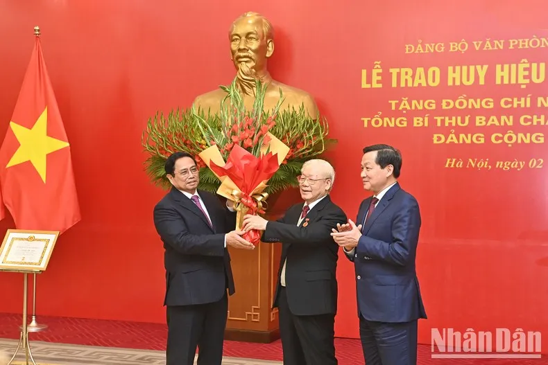 Thủ tướng Phạm Minh Chính và Phó Thủ tướng Lê Minh Khái tặng hoa chúc mừng Tổng Bí thư Nguyễn Phú Trọng. Ảnh: Báo Nhân dân