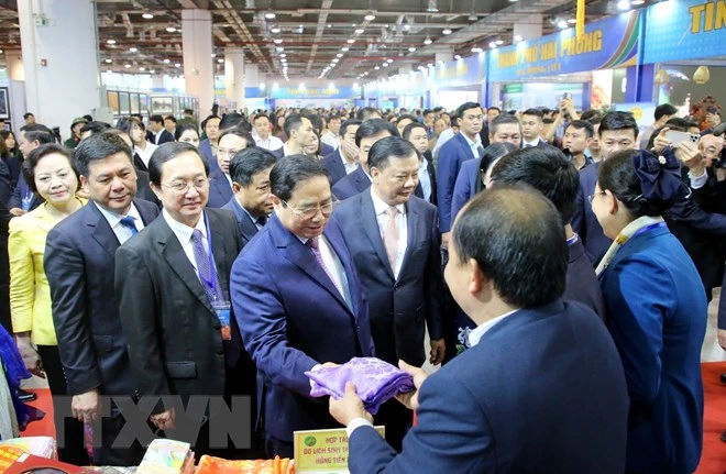 Thủ tướng cùng các đại biểu tham quan các gian hàng của các địa phương. Ảnh: TTXVN