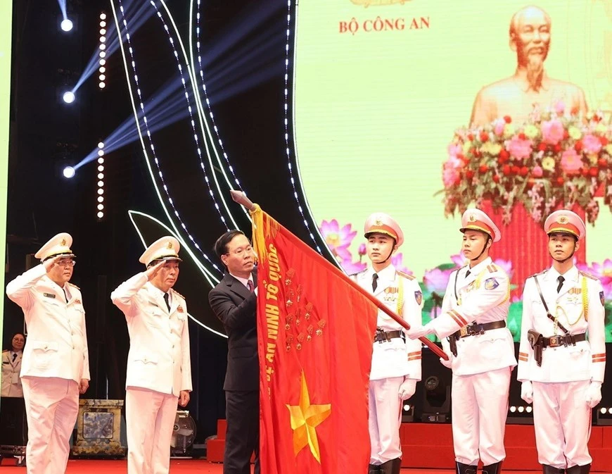 Chủ tịch nước Võ Văn Thưởng gắn Huân chương Bảo vệ Tổ quốc Hạng Nhất lên lá cờ truyền thống Xây dựng lực lượng công an nhân dân.