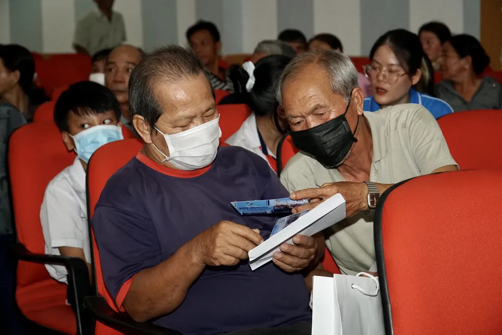 Ngư dân Đỗ Ngọc Thanh (bìa phải) đang trò chuyện với một người bạn trước giờ diễn ra chương trình. Ảnh: VĂN HÀ